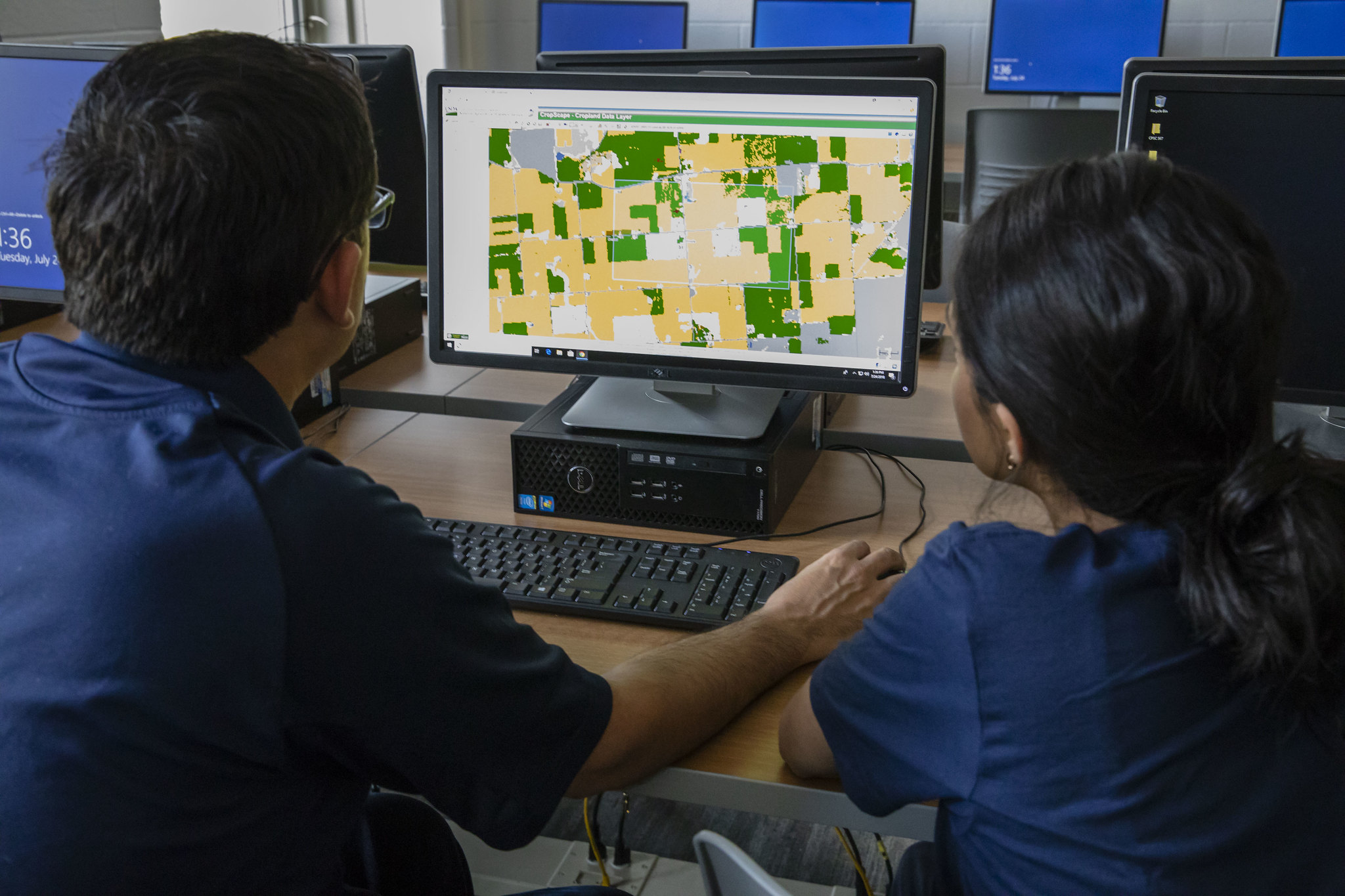 Students studying crop plots on a computer.