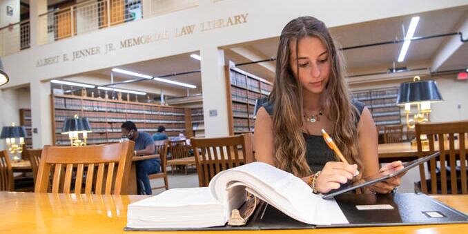 Student reading a book in the law library