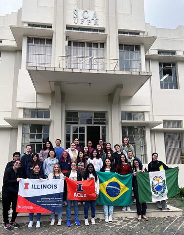 Group of students holding signs in front of Brazilian university building