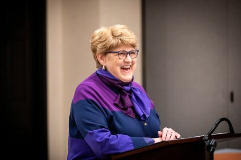 Kay Whitlock stands at a podium.