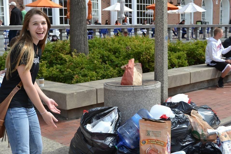 Maddy Liberman next to pile of trash on campus 