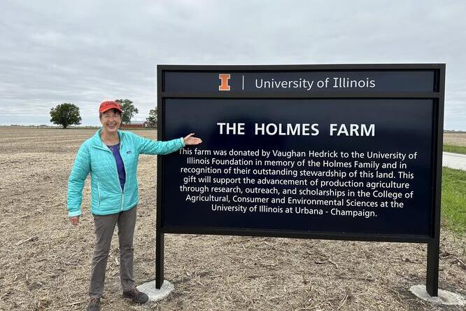Vaughan Hedrick gestures to the "The Holmes Farm" dedication sign, denoting its gift to the University of Illinois Urbana-Champagin..