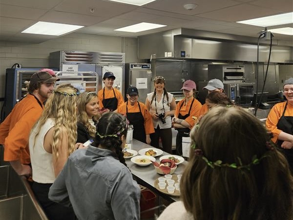 Students gather around a table as they prepare to open the restaurant.