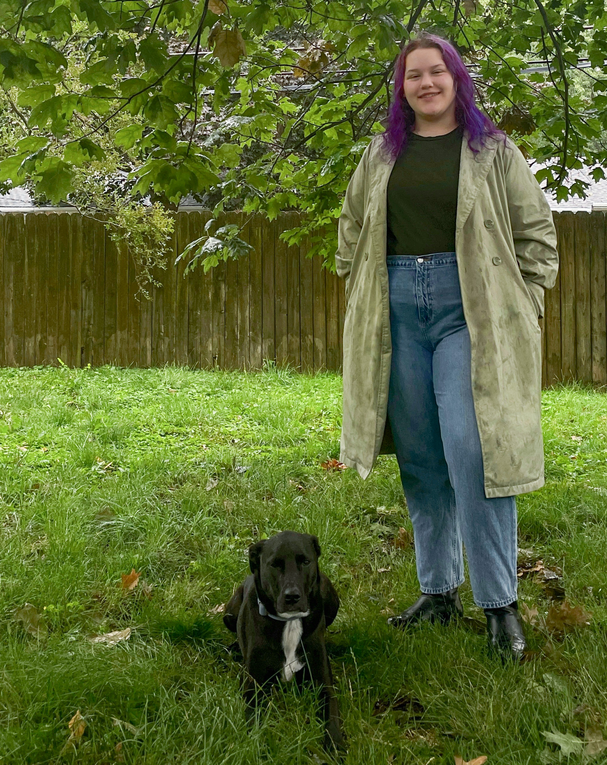 Black lab laying down with a woman to the right standing