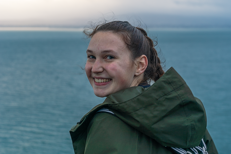 Erica smiles over her shoulder in front of the Irish Sea