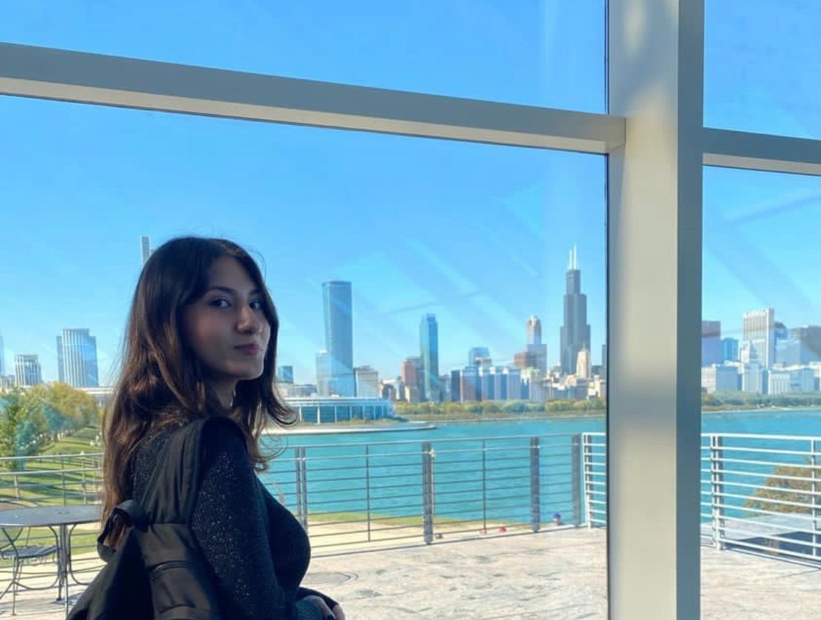 Photo of Julie Roman-Catalan standing in front of a window.