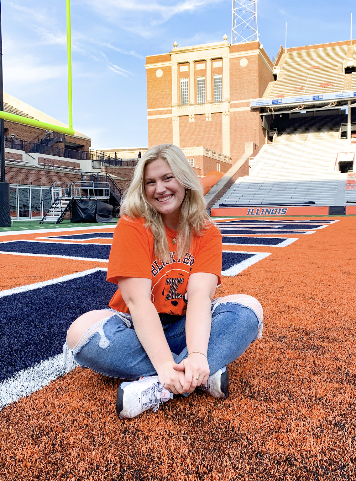 Katie Landers sitting on the Illini football field