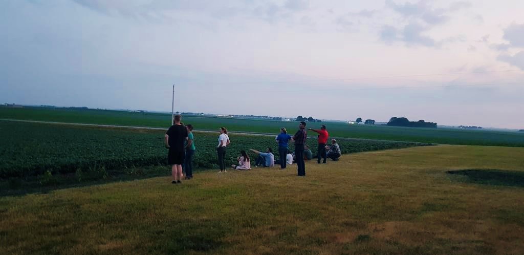 people sitting near a beanfield 