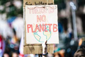 Student holding a sign that reads "there is no planet B."