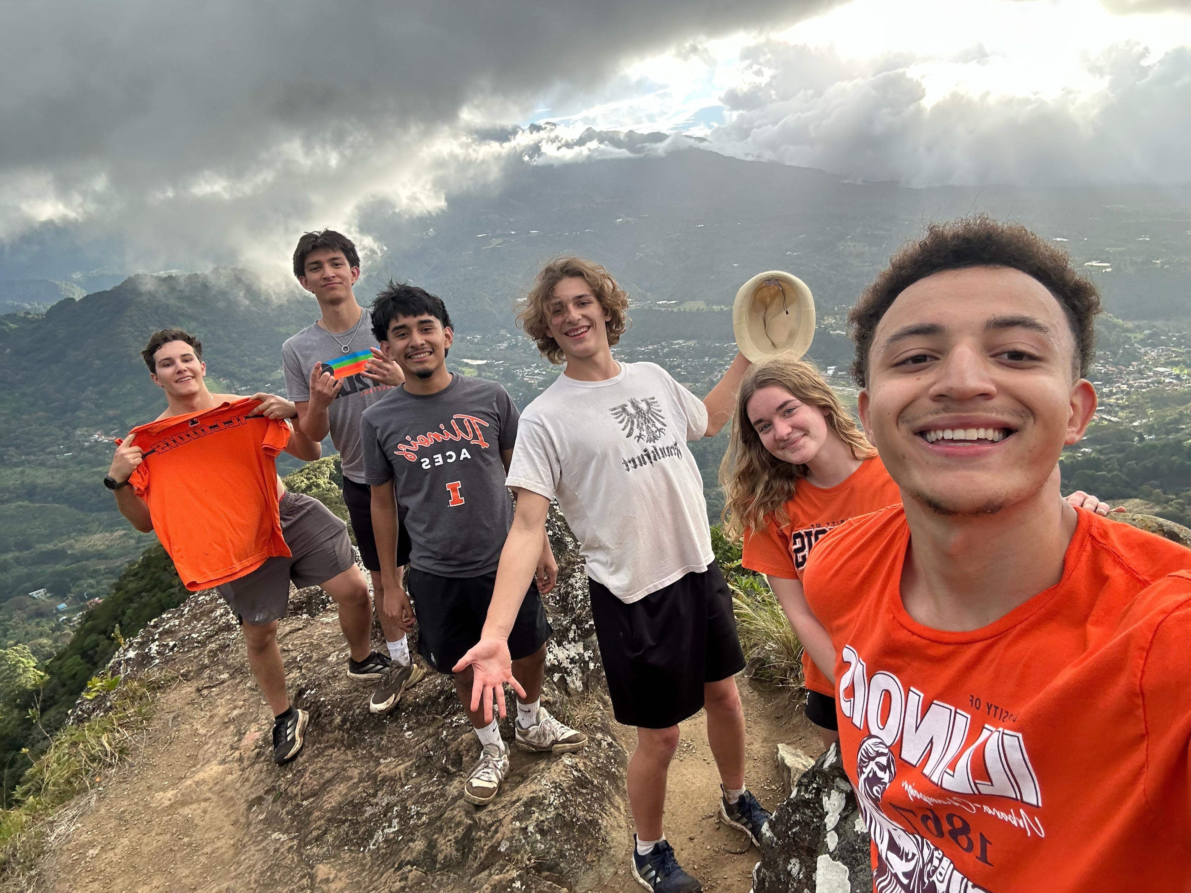 Students smiling on top of mountain
