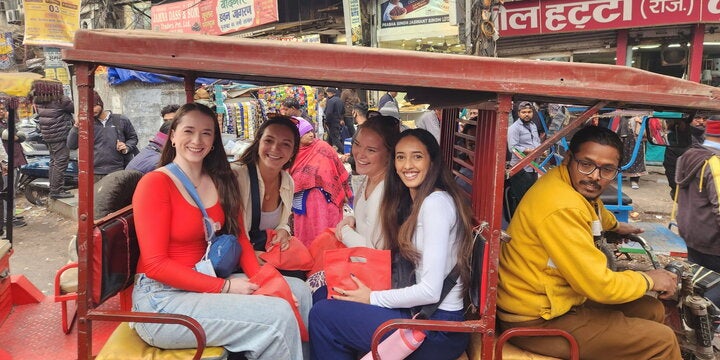 Four students in a tuk-tuk in Delhi, India