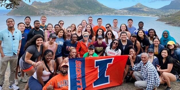 Students abroad holding up a University of Illinois flag.