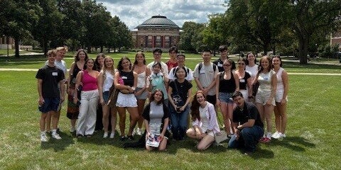 Group of exchange students on the main quad with the Foellinger Auditorium in the background. 
