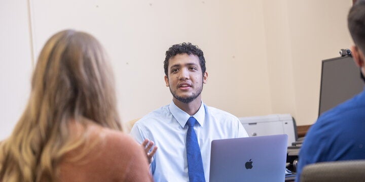 student talking with two other students