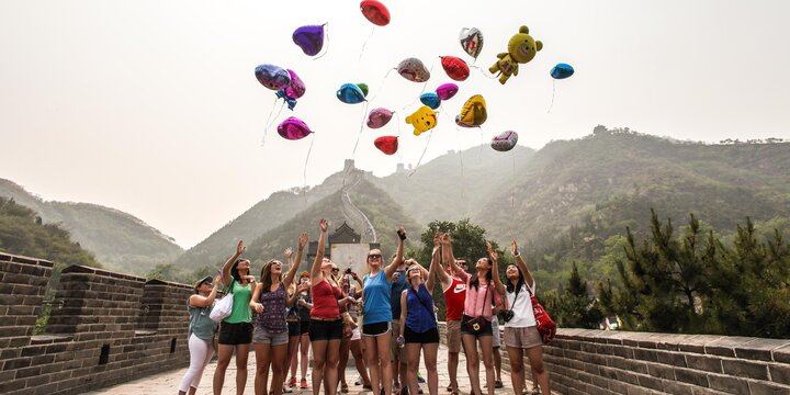 Study abroad students on the Great Wall of China releasing balloons