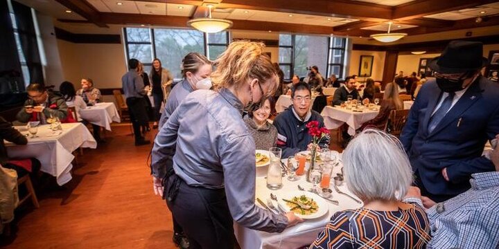 Student serving dinner at the Spicebox restaraunt.