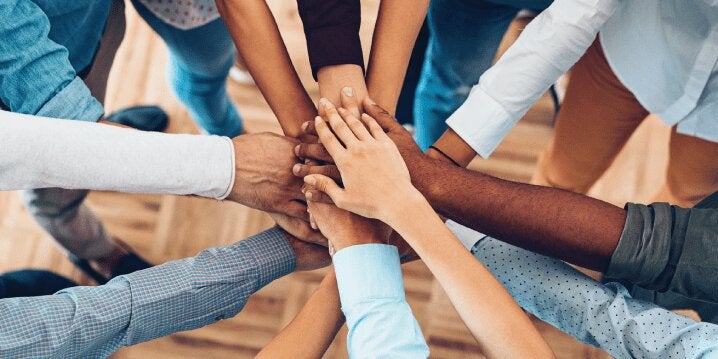 Hands stacked together in a circle.