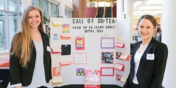 Students standing in front of a poster