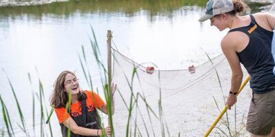 Students wading in a river.