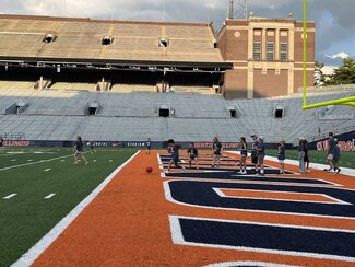 a group playing kickball on memorial stadium's field