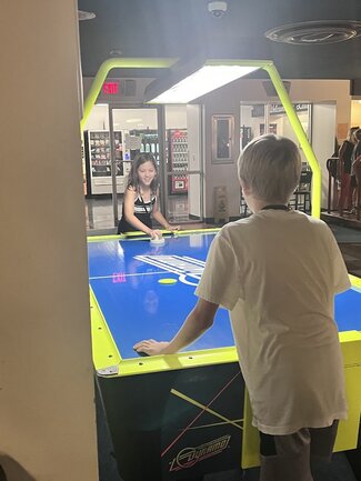 two participants playing air hockey