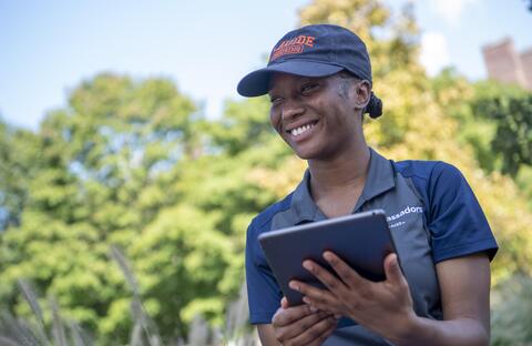 Student holding an iPad smiling