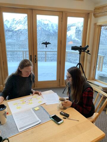 Two women at a table looking at papers