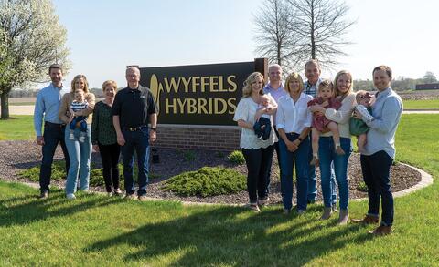 Extended family stands near Wyffels Hybrids sign