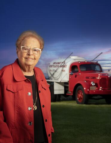 Evelyn Brandt Thomas stands in the foreground with a branded-BRANDT truck in the background.