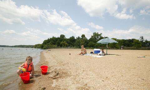 Kids play in the sand at Clinton Lake beach.