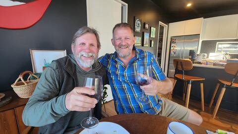 Bob Hauser and Hamish Gow share a drink together at a cafe.