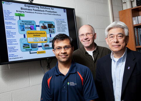 Three professors pictured in front of a screen depicting feedstock production.