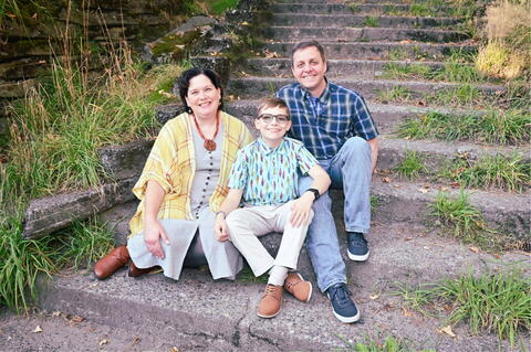 Family of three sitting on steps