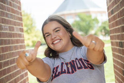 Student wearing an Illinois shirt with both thumbs up.
