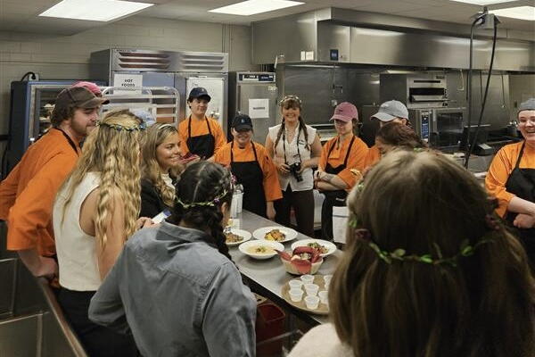 Students gather around a table as they prepare to open the restaurant.