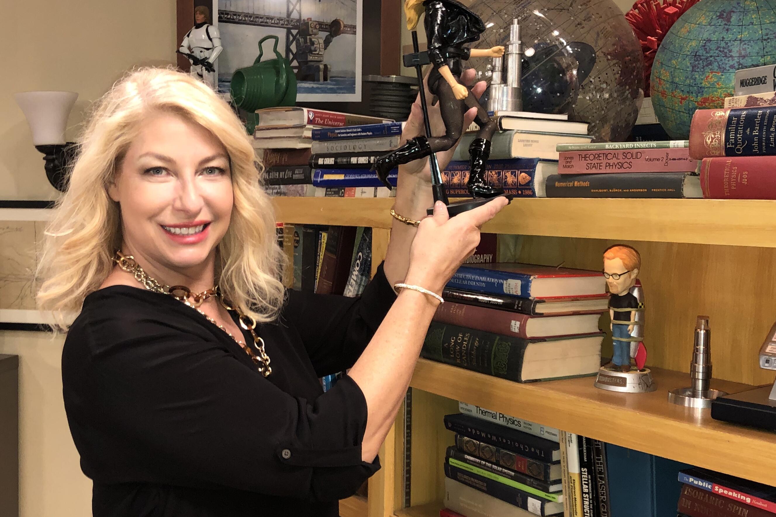 Ann Shea displaying a prop from the Big Bang Theory living room scene