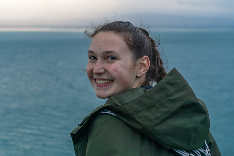 Erica smiles over her shoulder in front of the Irish Sea