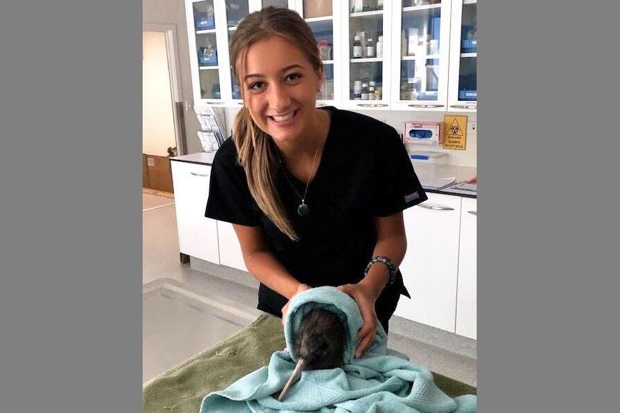 Dominique Krason holding an animal in a vet setting