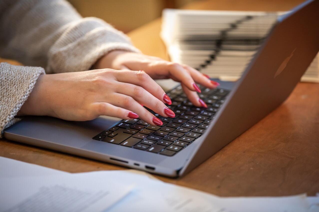 Close up of hands typing on a laptop