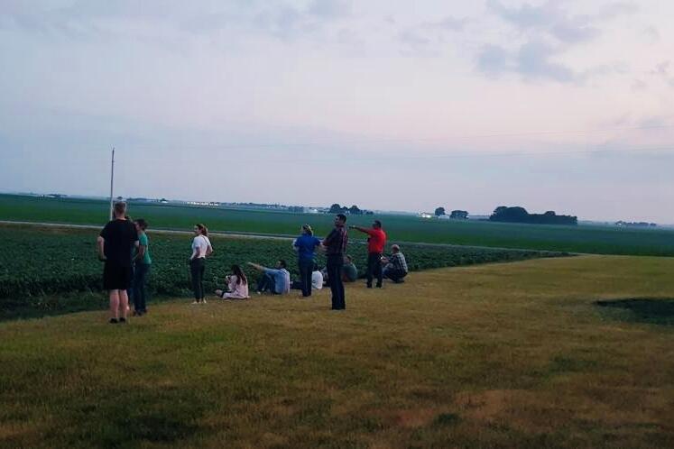 people sitting near a beanfield 