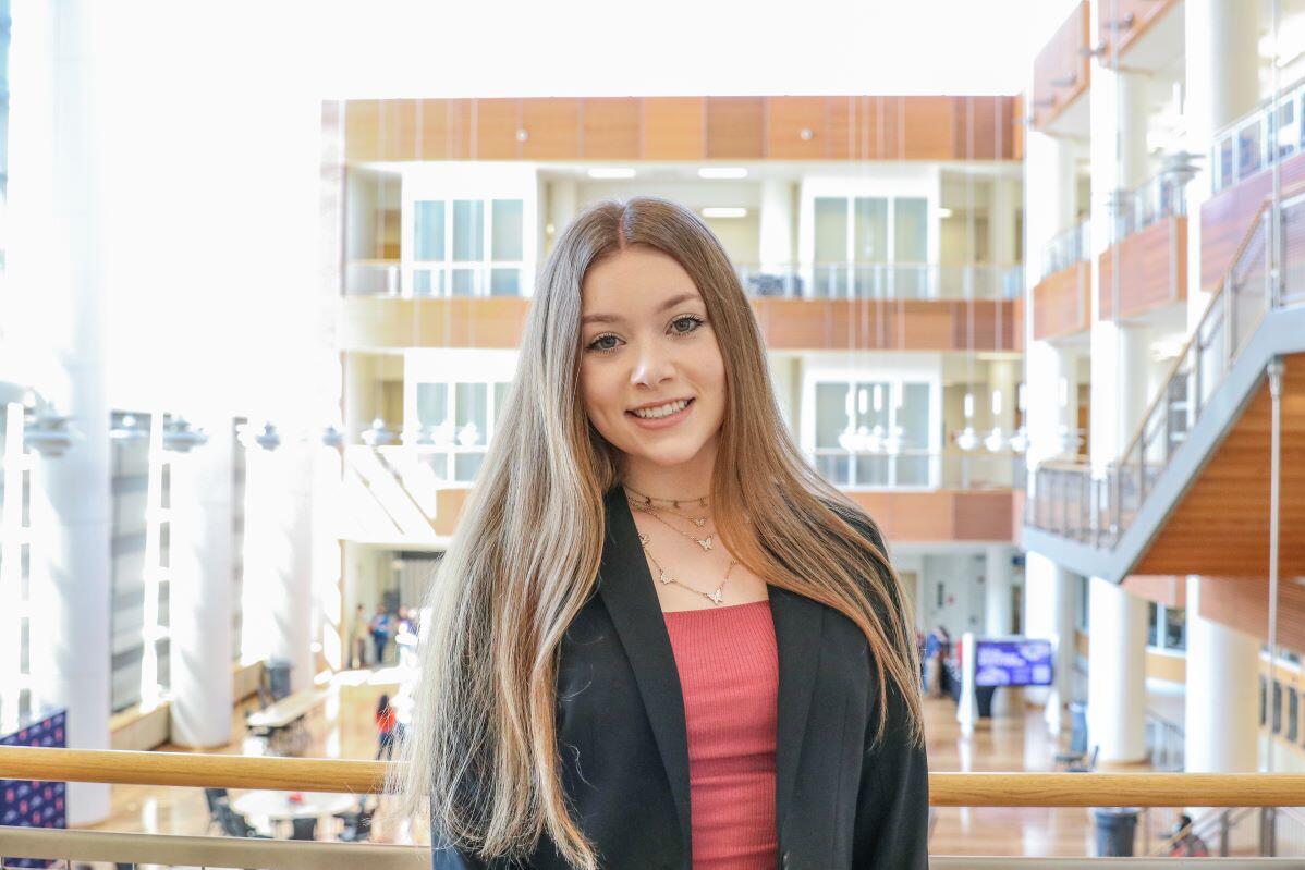 Young woman with long brown hair smiling at the camera