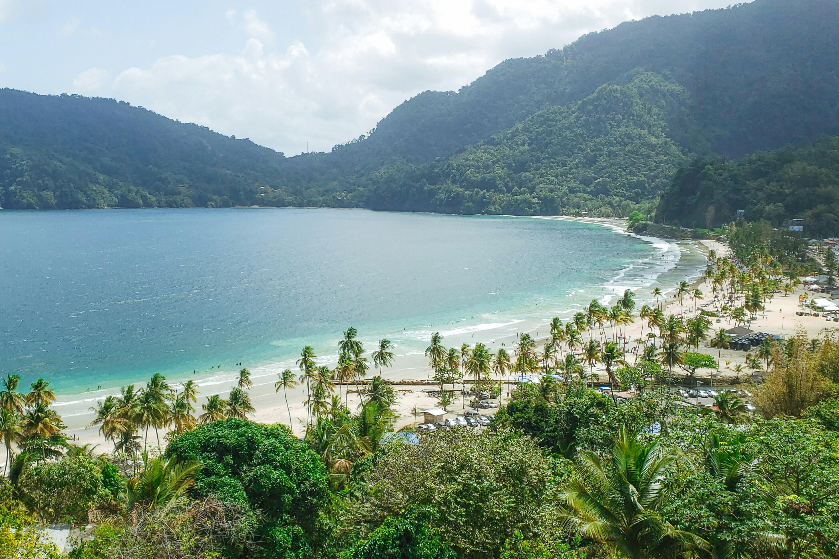 Trees and mountains surrounding the ocean.