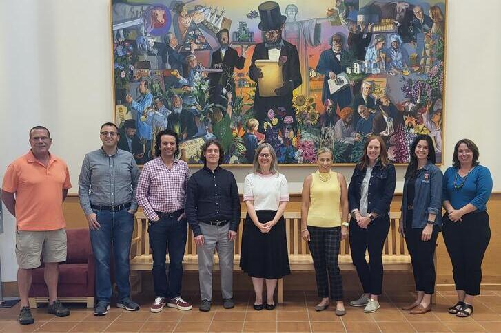 group of people in front of mural