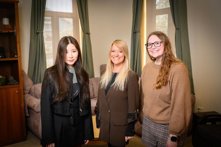 Sehyun Ju, Kelly Bost, and Samantha Iwinski standing in a living room setting 