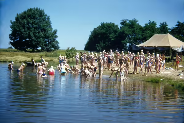 Vintage picture at camp. Vintage photo of a crowd of people wading into a lake.