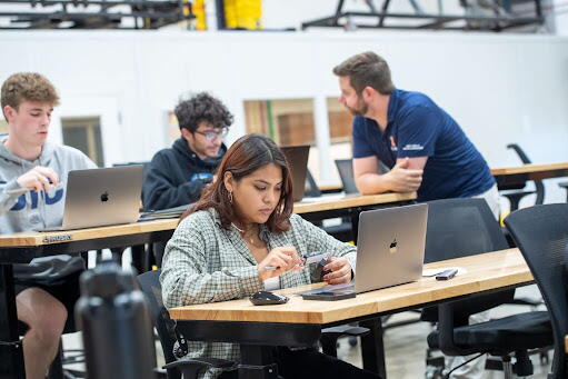 students work and talk at desks