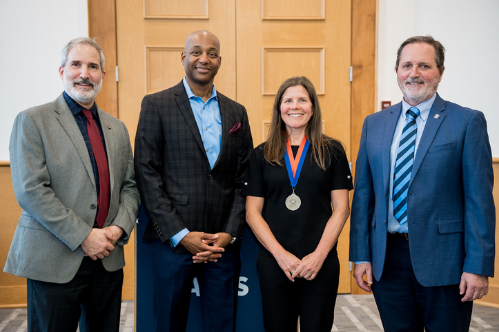 Lisa Ainsworth stands with newly awarded medal alongside Crop Sciences Department Head Adam Davis, Vice Chancellor Kevin Jackson, Charles Adlai Ewing Endowed Chair, and College of ACES Dean Germán Bollero, who pose together for a photo after the award ceremony