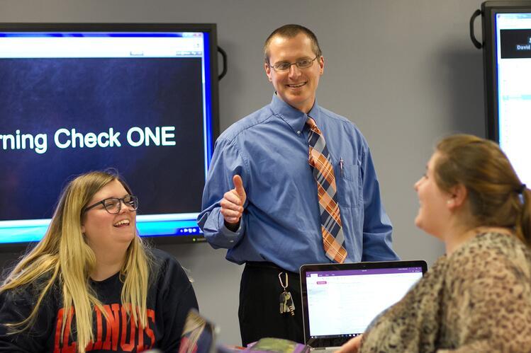 David Rosch in a classroom with two students