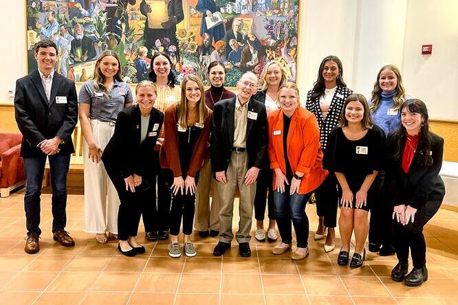 James F. Evans and a group of students pose in front of the large Abraham Lincoln painting in the ACES Library.