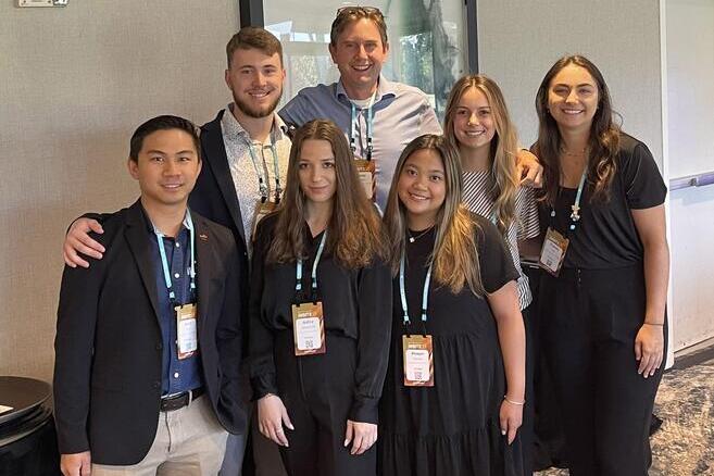 Craig Lemoine (mid center) poses with a group of students in the Financial Planning Program.